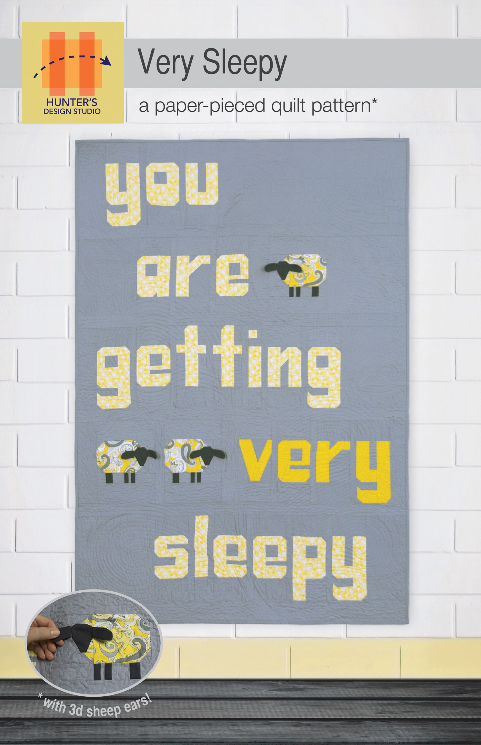 The Very Sleepy pattern cover features a quilt with a grey background, the words 'you are getting very sleepy' in pale and dark yellow and three black faced sheep.