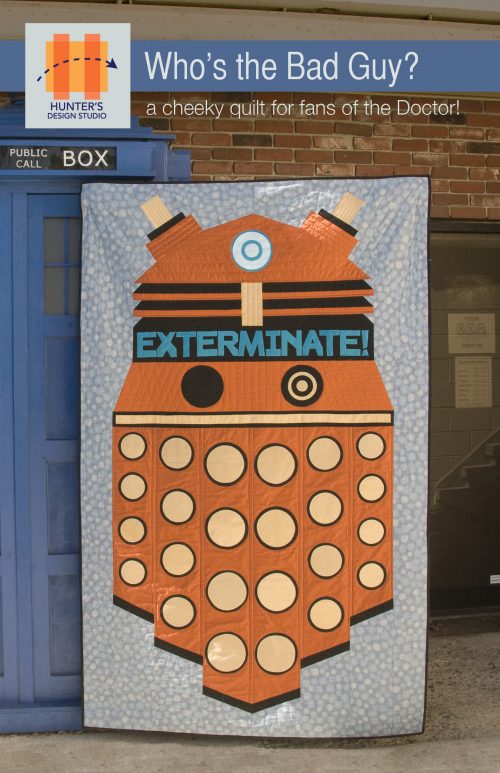 Image is of the Bad Guy quilt, featuring a Dr. Who inspired Dalek with the word EXTERMINATE on it. The Dalek is dark orange with black and tan circles.