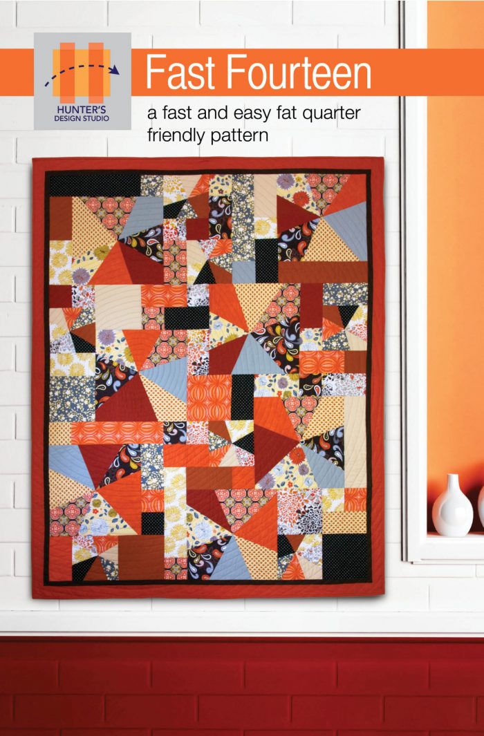Image is of the Fast Fourteen quilt pattern featuring orange, cream, yellow and blue print and solid fabrics.