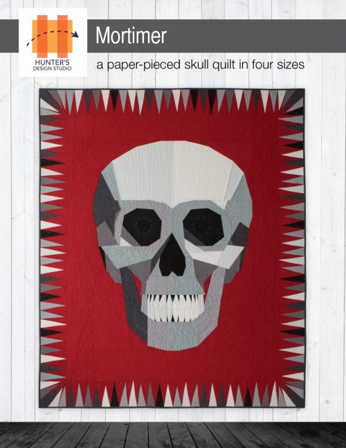 Mortimer is a foundation paper pieced skull quilt with a skinny triangle border.