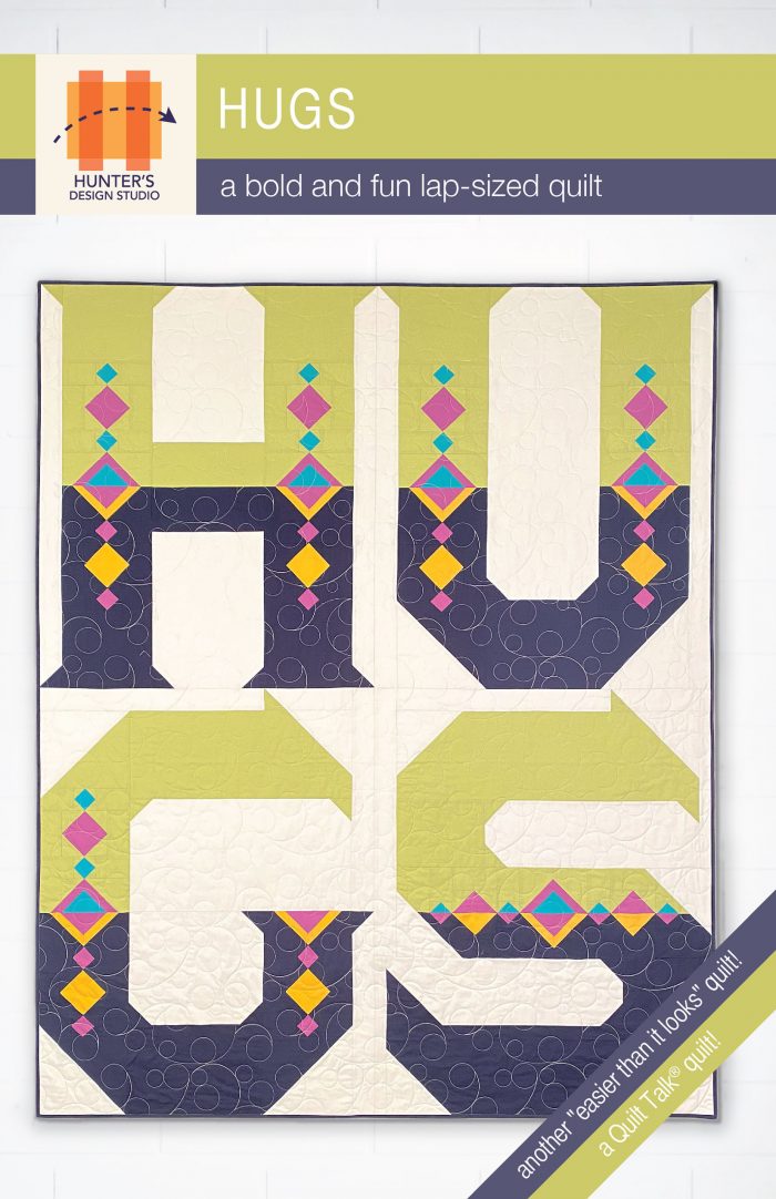 Hugs is a word quilt featuring the word 'hugs' arranged in a four patch. The letters are two colors and have multiple diamond details inside them.