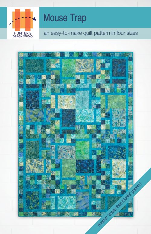 The Mouse Trap quilt pattern is pictured here featured in blue, green and aqua fabrics.