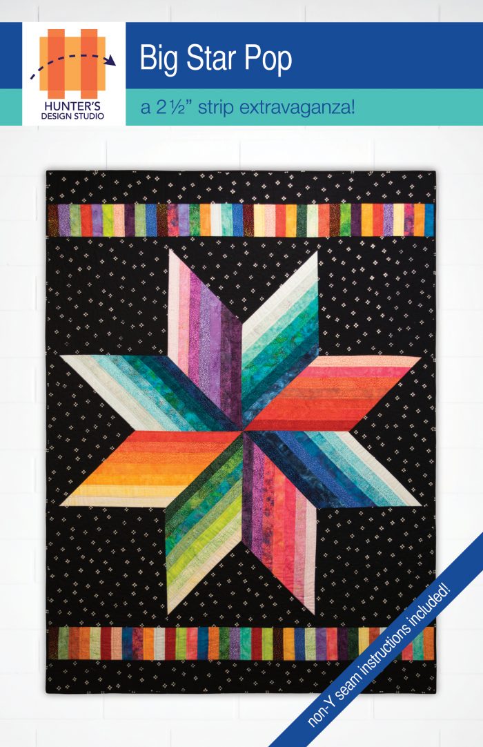 Big Star Pop is a large scale 8-pointed star quilt, made from 2.5 inch strips in rainbow fabrics on a black background.