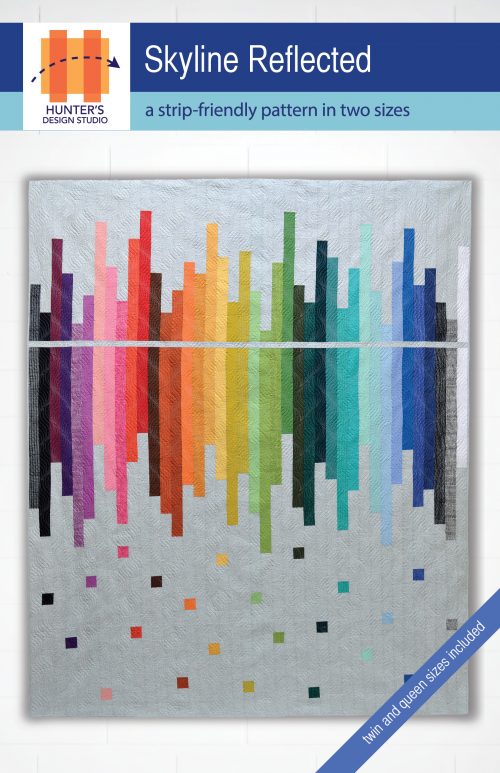 Skyline Reflected is a strip friendly multi-sized quilt pattern that is featured here in rainbow strips on a grey background