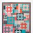 Churning Fourteen is a quilt where you can use your favorite fat quarters to construct the planned improv versions of this pattern featuring churn dash blocks.
